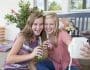 two girls having cold drink and clicking selfie