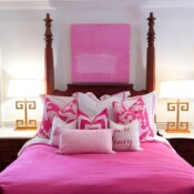 a pink color bed with many cushions and pillows