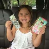 a cute little girl with a pouch and money in her hands